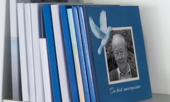 Bunte Buchrücken auf einem Regal, das vordere Buch zeigt ein Foto eines älteren Mannes und einen Text in Blau.